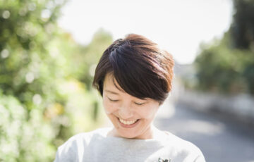 笑顔で下を向く女性写真